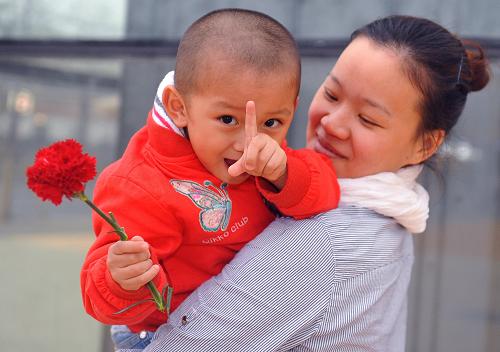 5月9日,在上海世博園內(nèi)游玩的陳栩印送給母親一支康乃馨,作為節(jié)日禮物。當(dāng)日是母親節(jié),母子、母女同游成為世博園內(nèi)溫馨一景。 新華社記者 羅曉光 攝