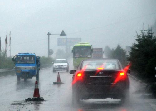 8月8日,吉林省通化市遭受暴雨襲擊,幾輛汽車在雨中行進(jìn)。新華社記者 齊海山 攝