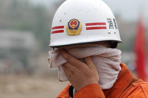 8月11日,消防官兵在擦拭臉上的汗水。新華社發(fā)(蔡國忠 攝)