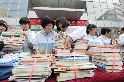9月26日,北京鋼院附中的學(xué)生將捐贈的課外圖書捆綁裝箱。新華社發(fā)(羅偉 攝)