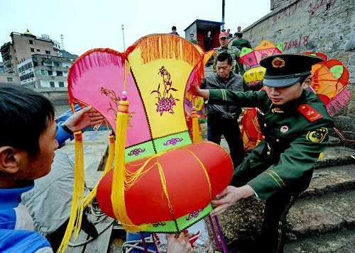 2月10日,連江黃岐邊防工作站工作人員和當(dāng)?shù)剜l(xiāng)親在黃岐碼頭裝運元宵花燈。新華社記者 張國俊 攝
