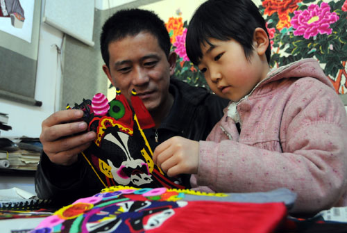 2月17日,在河北省蔚縣一家剪紙工作室,9歲的張潔(右)正在跟叔叔了解蔚縣剪紙的知識(shí)。新華社記者 鞏志宏 攝