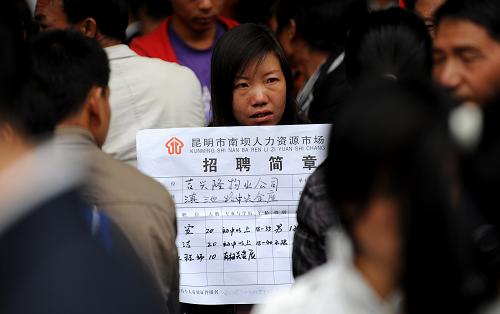 2月18日,一名招工者(中)在昆明市南壩人力資源市場(chǎng)內(nèi)展示招聘信息。新華社記者 藺以光 攝