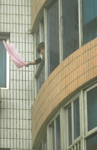 12月12日,一名被困在高樓中的女子揮舞毛巾求救。 當(dāng)日上午8時20分許,浙江省溫州市人民路溫富大廈發(fā)生火災(zāi),接到報警后,溫州市消防部門迅速前往撲救,營救出140多人。目前,火災(zāi)死亡人數(shù)已上升為21人。 新華社發(fā)