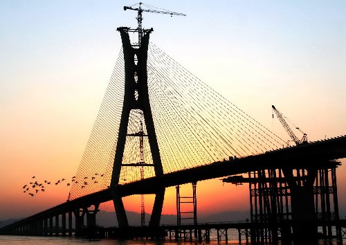夕陽中的瑞安大橋(2007年12月31日攝)。 1月2日,瑞安大橋合龍儀式在浙江省瑞安市舉行。瑞安大橋原名為飛云江三橋,大橋長近三千米,雙向六車道,建成后將緩解104國道瑞安段道路擁擠的狀況。 新華社發(fā)(莊穎昶 攝)
