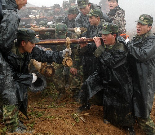 2月17日,解放軍官兵冒著雨雪將電線桿抬上山。當(dāng)日,成都軍區(qū)某部百名官兵在貴州省黔東南州三穗縣搶修遭受凝凍災(zāi)害的青穗輸電主干線。這條線路是三穗縣連接國(guó)家電網(wǎng)的主要通道。 新華社發(fā)(黃震 攝)