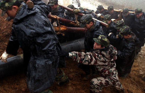 2月17日,解放軍官兵冒著雨雪將電線桿抬上山。當(dāng)日,成都軍區(qū)某部百名官兵在貴州省黔東南州三穗縣搶修遭受凝凍災(zāi)害的青穗輸電主干線。這條線路是三穗縣連接國(guó)家電網(wǎng)的主要通道。 新華社發(fā)(黃震 攝)