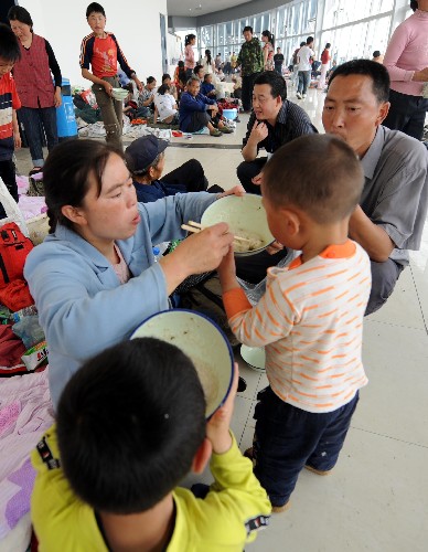 5月17日,來自北川縣的災民在綿陽九洲體育館安置點用餐。當日,記者在四川綿陽地震災區(qū)部分安置點采訪了解到,被臨時轉(zhuǎn)移安置的災民不僅有衣穿、有水喝、有飯吃,當?shù)卣€為他們提供了周到細致的服務,災民情緒比較穩(wěn)定。新華社記者 李曉果 攝