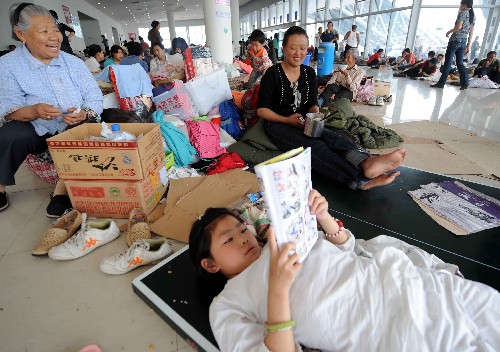 5月17日,一位女孩在綿陽九洲體育館安置點看書。當日,記者在四川綿陽地震災區(qū)部分安置點采訪了解到,被臨時轉(zhuǎn)移安置的災民不僅有衣穿、有水喝、有飯吃,當?shù)卣€為他們提供了周到細致的服務,災民情緒比較穩(wěn)定。 新華社記者 李曉果攝