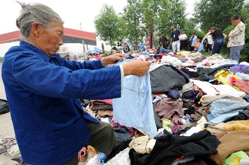 5月17日,災民在綿陽九洲體育館安置點領(lǐng)取各界捐贈的衣物。當日,記者在四川綿陽地震災區(qū)部分安置點采訪了解到,被臨時轉(zhuǎn)移安置的災民不僅有衣穿、有水喝、有飯吃,當?shù)卣€為他們提供了周到細致的服務,災民情緒比較穩(wěn)定。新華社記者 李曉果攝