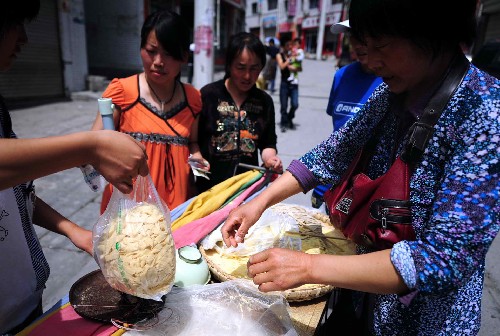 5月18日,文縣縣城一名商販在出售手工面條。 甘肅省隴南市文縣是受汶川地震影響損失最嚴重的縣。災(zāi)害發(fā)生后,文縣各有關(guān)部門采取措施,穩(wěn)定市場,保證市場供給,目前災(zāi)區(qū)物資供應(yīng)基本恢復(fù)正常。 新華社記者 張錳 攝