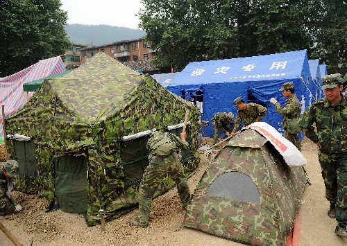 5月20日,解放軍官兵在四川省青川縣城為受災(zāi)群眾搭建臨時帳篷。 當(dāng)日下午,廣元市青川縣抗震救災(zāi)指揮部稱,青川縣城后山出現(xiàn)山體裂縫,威脅5萬受災(zāi)群眾和救災(zāi)部隊的安全。目前直接受災(zāi)害威脅的近9000名群眾已被緊急疏散。當(dāng)?shù)卣?4小時派專人監(jiān)測,嚴(yán)禁人員進入危險區(qū)。 新華社記者 藺以光 攝