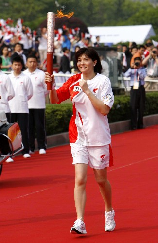 5月23日,火炬手莊泳手持火炬?zhèn)鬟f。當(dāng)日,北京奧運(yùn)會(huì)圣火在上海傳遞。 新華社記者 凡軍 攝