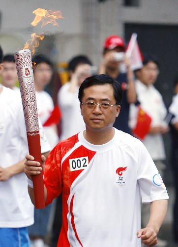 5月24日,剛剛完成了第一階段抗震救災(zāi)任務(wù)歸來(lái)的上海市公安消防總隊(duì)總隊(duì)長(zhǎng)陳飛少將手持火炬?zhèn)鬟f。當(dāng)日,北京奧運(yùn)會(huì)圣火繼續(xù)在上海傳遞。 新華社記者凡軍攝
