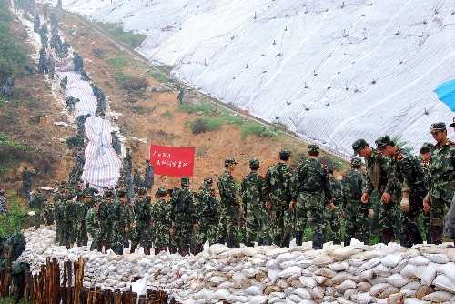 6月18日,戰(zhàn)士們用沙袋筑堤防止山體滑坡。 6月15日,持續(xù)強降雨造成京廣鐵路廣東清遠龍?zhí)炼窝鼐€6處山體滑坡,部分路段嚴重淤積和內(nèi)澇。為防止山體滑坡影響京廣交通大動脈,上千名駐軍、武警官兵和群眾趕赴現(xiàn)場,對險患地段進行搶險加固,確保鐵路運營安全。 新華社發(fā)(李作描 攝)