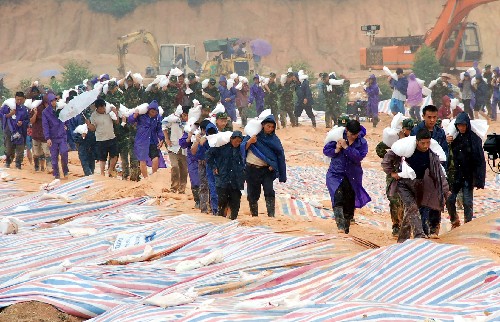 6月18日,當?shù)伛v軍、武警官兵和群眾搬運沙袋。 6月15日,持續(xù)強降雨造成京廣鐵路廣東清遠龍?zhí)炼窝鼐€6處山體滑坡,部分路段嚴重淤積和內(nèi)澇。為防止山體滑坡影響京廣交通大動脈,上千名駐軍、武警官兵和群眾趕赴現(xiàn)場,對險患地段進行搶險加固,確保鐵路運營安全。 新華社發(fā)(李作描 攝)