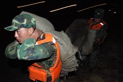 8月4日凌晨,安徽省軍區(qū)解放軍戰(zhàn)士在搬運麻袋。7月31日以來的強降雨致使安徽滁河、得勝河、清溪河等長江支流出現(xiàn)超保證水位的嚴(yán)峻汛情。8月3日下午,滁河大公莊段出現(xiàn)重大險情,大堤發(fā)生100余米塌方,安徽省軍區(qū)和武警部隊迅速出動2500多名官兵,連續(xù)奮戰(zhàn)加固大堤,使險情得到了有效控制,確保了堤內(nèi)上萬名群眾的生命財產(chǎn)安全。 新華社記者 李健 攝