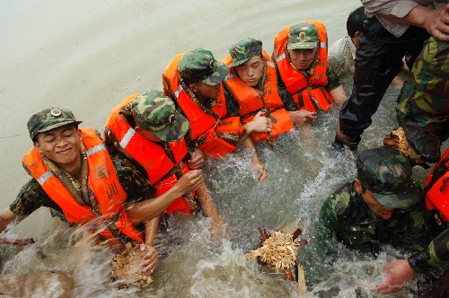 8月4日,南京軍區(qū)駐皖某紅軍團(tuán)戰(zhàn)士在滁河教場(chǎng)圩筑起人墻阻擋洪水。7月31日至8月2日以來(lái)的強(qiáng)降雨致使安徽滁河、得勝河、清溪河等長(zhǎng)江支流出現(xiàn)超保證水位的嚴(yán)峻汛情。截至3日14時(shí),滁河襄河口閘水位為13.83米,超過(guò)保證水位0.33米,滁河流域內(nèi)發(fā)生多處險(xiǎn)情,防汛形勢(shì)仍然嚴(yán)峻。 新華社記者 李健 攝
