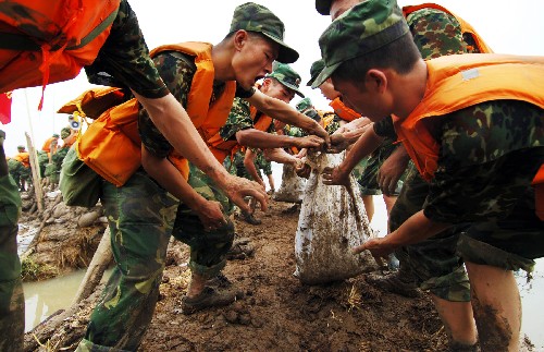 8月4日,南京軍區(qū)駐皖某紅軍團(tuán)戰(zhàn)士在滁河教場(chǎng)圩搬運(yùn)沙袋加固圩堤。7月31日至8月2日以來(lái)的強(qiáng)降雨致使安徽滁河、得勝河、清溪河等長(zhǎng)江支流出現(xiàn)超保證水位的嚴(yán)峻汛情。截至3日14時(shí),滁河襄河口閘水位為13.83米,超過(guò)保證水位0.33米,滁河流域內(nèi)發(fā)生多處險(xiǎn)情,防汛形勢(shì)仍然嚴(yán)峻。 新華社記者 李健 攝