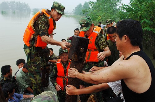 8月4日,南京軍區(qū)駐皖某紅軍團(tuán)戰(zhàn)士在滁河教場(chǎng)圩打樁加固圩堤。7月31日至8月2日以來(lái)的強(qiáng)降雨致使安徽滁河、得勝河、清溪河等長(zhǎng)江支流出現(xiàn)超保證水位的嚴(yán)峻汛情。截至3日14時(shí),滁河襄河口閘水位為13.83米,超過(guò)保證水位0.33米,滁河流域內(nèi)發(fā)生多處險(xiǎn)情,防汛形勢(shì)仍然嚴(yán)峻。 新華社記者 李健 攝