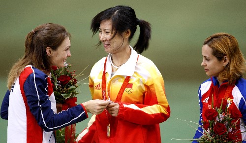 8月14日,中國(guó)選手杜麗(中)在領(lǐng)獎(jiǎng)臺(tái)上接受捷克選手埃蒙斯(左)贈(zèng)送的小禮物。 當(dāng)日,在北京奧運(yùn)會(huì)射擊女子50米步槍三姿決賽中,中國(guó)選手杜麗獲得金牌,捷克選手埃蒙斯獲得銀牌,古巴選手克魯茲獲銅牌。 新華社記者 鮑菲菲 攝