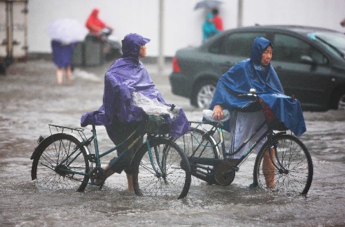 8月25日,上海市民在雨中行進。當日清晨,上海突遭強雷暴雨襲擊,局部地區(qū)雨量已達大暴雨程度,1個半小時內雨量超過了100毫米。 新華社記者 裴鑫攝