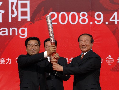 9月4日,北京奧組委執(zhí)行副主席蔣效愚(右)與河南省委常委、洛陽(yáng)市委書記連維良(左)共同舉起火炬。當(dāng)日,北京殘奧會(huì)圣火在河南洛陽(yáng)進(jìn)行傳遞。 新華社記者 金良快 攝