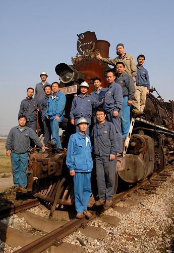 新鋼公司曾經(jīng)的蒸汽機(jī)車司機(jī)和他們的“老伙計(jì)”合影留念(2008年11月13日攝)。新華社發(fā)(趙春亮 攝)
