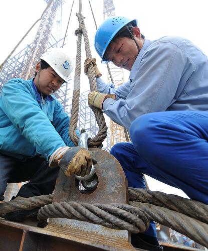 12月2日,兩名農(nóng)民工在天津百萬噸乙烯工程工地進(jìn)行吊裝作業(yè)。在天津100萬噸/年乙烯及配套工程建設(shè)現(xiàn)場,有2500多名農(nóng)民工與中國石化第四建設(shè)公司職工一起奮戰(zhàn)在10多個(gè)大型施工工地。新華社記者 劉海峰 攝