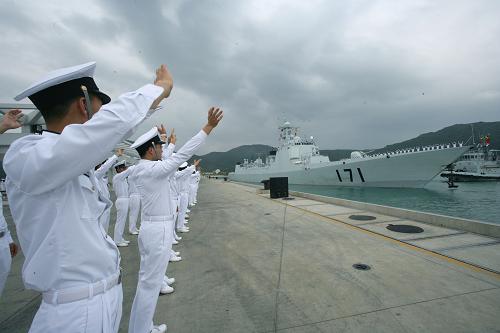 12月26日下午,海軍官兵在三亞軍港向出征軍艦揮手送行。新華社記者 查春明攝