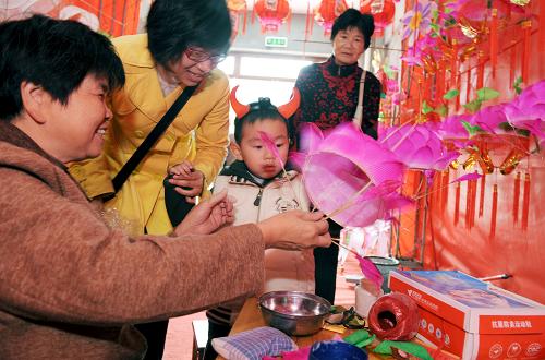 2月4日,市民在福州南后街觀看傳統(tǒng)花燈的制作過程。元宵佳節(jié)臨近,福州傳統(tǒng)花燈一條街——南后街被各色花燈裝扮一新,近百家花燈商鋪生意日益紅火,市民不僅可以在這里購買到喜愛的花燈,還可以觀賞傳統(tǒng)花燈的制作過程。新華社記者 姜克紅 攝
