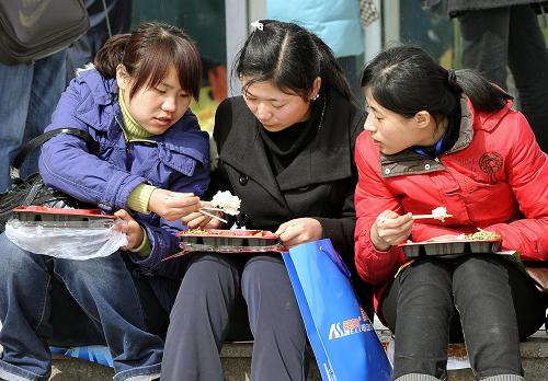 2月21日,三位畢業(yè)生在招聘會(huì)場(chǎng)外吃午飯。當(dāng)日,山東省應(yīng)屆畢業(yè)生春季雙選會(huì)在濟(jì)南市國(guó)際會(huì)展中心舉行。新華社記者 朱崢 攝