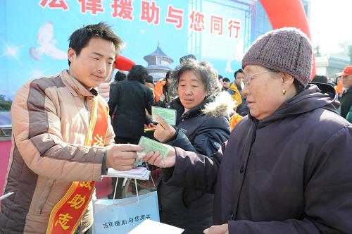 2月26日,志愿者在發(fā)放“法律援助惠民服務戶卡”。當日,北京市門頭溝區(qū)司法局舉辦“法律援助與您同行”宣傳活動,宣傳即將實施的《北京市法律援助條例》。新華社發(fā)(李青山 攝)