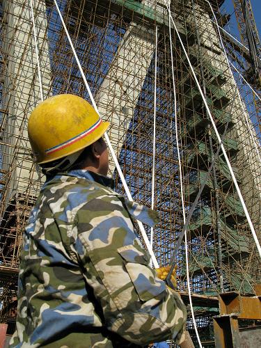 4月21日,施工人員在天津南倉(cāng)道立交橋建設(shè)現(xiàn)場(chǎng)吊裝鋼筋。目前,天津市又一座大型互通式立交橋——南倉(cāng)道立交橋經(jīng)過(guò)一年多的建設(shè)已初具規(guī)模,主塔接近封頂。南倉(cāng)道立交橋?yàn)殡p塔連體四索面斜拉橋,塔高109米,橋長(zhǎng)1060米。橫跨52條鐵路線的南倉(cāng)道立交橋建成后,將成為濱海新區(qū)以及天津市區(qū)至西北環(huán)線的重要交通樞紐。新華社發(fā)(王國(guó)慶 攝)