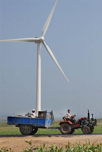 8月7日,一輛拖拉機(jī)拉著拖斗從風(fēng)力發(fā)電機(jī)旁駛過。在內(nèi)蒙古自治區(qū)興安盟的境內(nèi),時(shí)常能夠看到公路兩旁矗立著一座座高大的風(fēng)力發(fā)電機(jī)。據(jù)統(tǒng)計(jì),截至5月底,內(nèi)蒙古自治區(qū)風(fēng)電并網(wǎng)已達(dá)315.28萬千瓦,居全國(guó)第一。近年來,風(fēng)電開發(fā)不僅帶動(dòng)了當(dāng)?shù)氐南嚓P(guān)產(chǎn)業(yè),因風(fēng)電工程建設(shè)鋪設(shè)的公路,使當(dāng)?shù)氐慕煌l件也得到了很大改善,“風(fēng)車動(dòng),道路通”,成了草原新景觀。新華社記者 王頌 攝