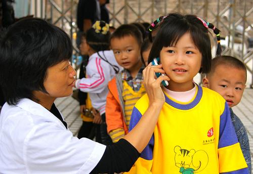 10月9日早晨,江西省靖安縣幼兒園的校醫(yī)對假期后返園的孩子進(jìn)行體溫檢測。當(dāng)天是中小學(xué)、幼兒園在長假后正式上課的第一天,各地紛紛采取措施,嚴(yán)防甲流在校園和幼兒園蔓延。新華社發(fā)(徐仲庭 攝)