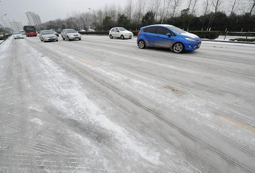 2月11日,汽車在南京市區(qū)積雪結(jié)冰的道路上行駛。當(dāng)日,南京出現(xiàn)降雪和低溫冰凍天氣,江蘇省氣象臺發(fā)布道路結(jié)冰橙色預(yù)警。目前,因路面積雪結(jié)冰,南京周邊高速公路封閉,長途車站大批旅客滯留。新華社記者 孫參 攝