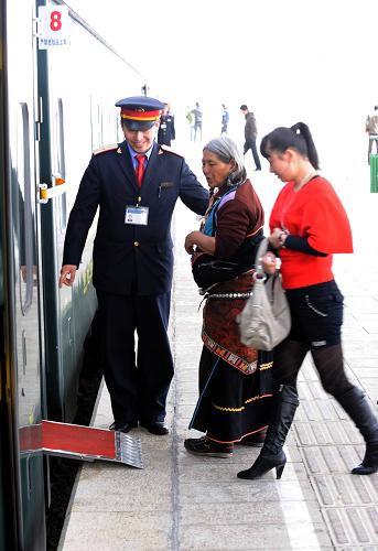 這是京藏車(chē)隊(duì)第九包乘組列車(chē)員在那曲車(chē)站幫助旅客上車(chē)(3月28日攝)。北京客運(yùn)段京藏車(chē)隊(duì)值乘的T27/28次列車(chē),從北京至拉薩全程4064公里, 單程運(yùn)行約46小時(shí)30分。在青藏鐵路線上,京藏車(chē)隊(duì)470多名乘務(wù)人員克服高寒缺氧等困難,為廣大旅客提供了熱情周到的優(yōu)質(zhì)服務(wù)。他們注重提高服務(wù)細(xì)節(jié),先后推出了漢、藏、英三種語(yǔ)言服務(wù),以及10多種藏、回菜肴和介紹高原風(fēng)光等13項(xiàng)服務(wù)內(nèi)容,架起了民族團(tuán)結(jié)的橋梁。新華社記者 唐召明 攝