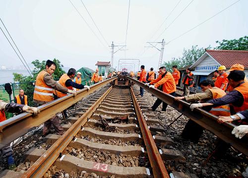5月10日,工人們?yōu)榫沤L江大橋鐵路橋南引橋上行線更換鋼軌。當(dāng)日,南昌鐵路局組織相關(guān)單位人員開始為九江長江大橋鐵路橋更換鋼軌。這是九江長江大橋鐵路橋20世紀(jì)90年代建成通車后首次全面更換鋼軌,大橋上、下行線路共計(jì)16公里的鋼軌計(jì)劃6月底全部更換完畢。新華社發(fā)(胡國林 攝)