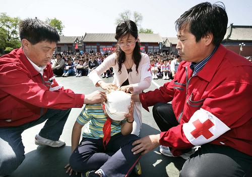 5月11日,在北京府學(xué)小學(xué)舉行的防災(zāi)演練中,3名教師為一名學(xué)生包扎“傷口”。 在5月12日第二個(gè)國(guó)家“防災(zāi)減災(zāi)日”到來(lái)之際,各地中小學(xué)紛紛在校園內(nèi)舉行防災(zāi)減災(zāi)演練,旨在增強(qiáng)師生們的防災(zāi)減災(zāi)意識(shí)并提高應(yīng)急自救知識(shí)技能。新華社發(fā)(張傳東 攝)
