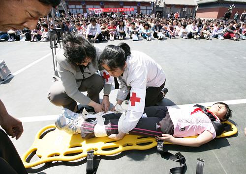 5月11日,在北京府學(xué)小學(xué)舉行的防災(zāi)演練中,兩名教師在救護(hù)一名“受傷”學(xué)生。在5月12日第二個(gè)國(guó)家“防災(zāi)減災(zāi)日”到來(lái)之際,各地中小學(xué)紛紛在校園內(nèi)舉行防災(zāi)減災(zāi)演練,旨在增強(qiáng)師生們的防災(zāi)減災(zāi)意識(shí)并提高應(yīng)急自救知識(shí)技能。新華社發(fā)(張傳東 攝)