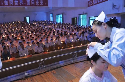 5月12日,在廣東河源市衛(wèi)生學(xué)校舉行的護(hù)士授帽儀式上,教師為護(hù)理專(zhuān)業(yè)畢業(yè)生授帽。當(dāng)日是國(guó)際護(hù)士節(jié),廣東河源市衛(wèi)生學(xué)校為該校1000多名應(yīng)屆護(hù)理專(zhuān)業(yè)畢業(yè)生舉行護(hù)士授帽儀式。新華社發(fā)(黃贊福 攝)
