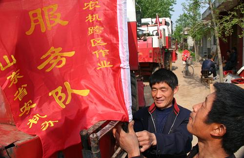 5月12日,山東省郯城縣郯城鎮(zhèn)紅青農(nóng)機服務合作社農(nóng)機手在收割機上插上隊旗準備出征。當日起,山東省郯城縣1000余臺安裝有秸稈切碎裝置的收割機將陸續(xù)前往河南、安徽、湖北等地進行跨區(qū)麥收作業(yè)。山東省郯城縣農(nóng)機部門組織技術人員深入到村,舉辦培訓班,送發(fā)跨區(qū)作業(yè)證,為機手備戰(zhàn)跨區(qū)作業(yè)提供服務。新華社發(fā)(張春雷 攝)