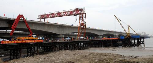 這是建設中的錢江鐵路新橋(5月26日攝)。5月26日,我國首座四線高速鐵路連續(xù)橋梁——浙江杭州錢江鐵路新橋順利實現(xiàn)主橋精確合龍。2008年4月開工的錢江鐵路新橋是杭甬客運專線、滬昆客運專線關鍵控制性工程,全長2222米,其中主橋長1340米,由鐵道部、浙江省和杭州市共同出資組織建設。錢江鐵路新橋橋面設計為四線鐵路客運專線,并采取18跨整體連續(xù)梁橋結構,在我國高速鐵路橋梁中首次采用,設計時速為250公里。該橋是繼錢江一橋、錢江二橋之后錢塘江上建設的第三座鐵路橋梁。新華社記者 韓傳號 攝