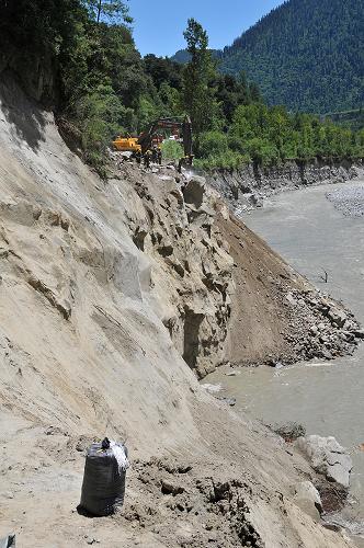 武警某部官兵在狹窄的山崖上打通垮塌道路(7月29日攝)。因冰雪消融引發(fā)泥石流導(dǎo)致川藏公路波密段連日來多處路段發(fā)生垮塌事故,道路搶通工作陷入極難困境。經(jīng)過武警某部官兵連續(xù)80多個(gè)小時(shí)的奮力搶修,目前已打通25日垮塌的一處70余米路段,26日垮塌的一處200多米的路基和29日垮塌的76米長的橋梁搶通工作都已進(jìn)入攻堅(jiān)階段。新華社發(fā)(劉云 攝)