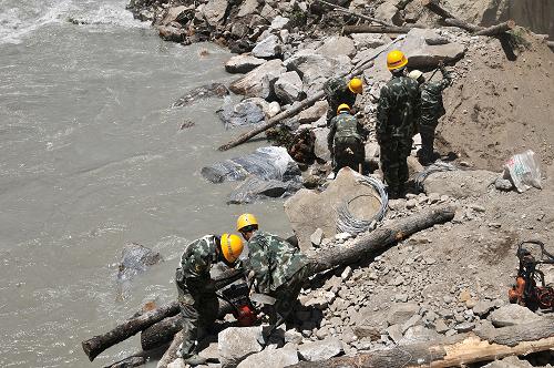 7月30日,武警某部官兵在垮塌路段搭建木籠。新華社發(fā)(劉云 攝)