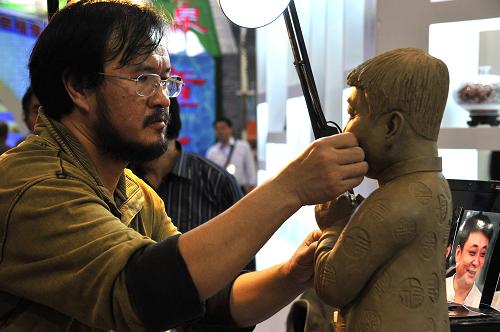 9月27日,在第三屆山東文博會上,山東陶藝家尹寶亭現(xiàn)場制作人像陶藝作品。當(dāng)日,第三屆山東文化產(chǎn)業(yè)博覽交易會在濟(jì)南正式拉開帷幕。文博會期間將集中展示孔子文化、齊文化、魯文化、紅色文化等富有濃厚山東地域特色的文化品牌體系,并向社會推介文化產(chǎn)業(yè)項(xiàng)目1376個(gè)。新華社記者 徐速繪 攝