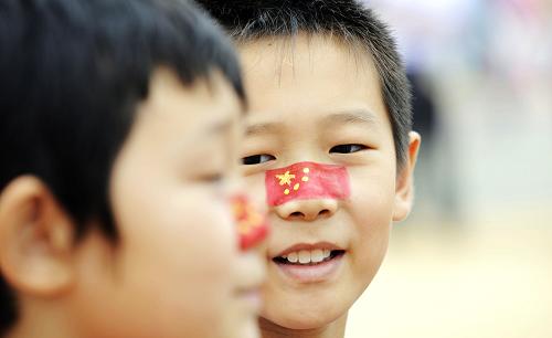 10月1日,來(lái)自河南的肖揚(yáng)(左)和薛博文在臉上彩繪國(guó)旗圖案,慶祝中國(guó)國(guó)家館日。當(dāng)日,上海世博會(huì)迎來(lái)中國(guó)國(guó)家館日。新華社記者王建華攝