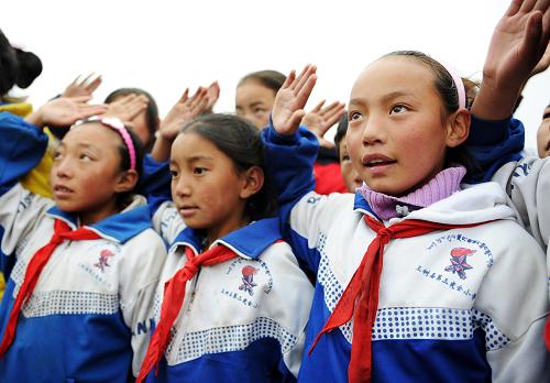 10月1日,玉樹藏族自治州玉樹縣第三完全小學(xué)五年級(jí)學(xué)生巴丁措毛(右一)等向國(guó)旗行少先隊(duì)隊(duì)禮。新華社記者張宏祥攝