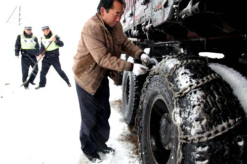 11月18日,在新疆富蘊縣省道226線上,一名駕駛員給車輪胎綁防滑鏈。當日,新疆阿勒泰地區(qū)富蘊縣普降小到中雪,造成省道226線19公里至20公里處道路結冰,致使150余輛車受阻。經過相關部門緊急處理,20時許,該路段滯留的車輛已全部疏通。新華社發(fā)(丁寧 攝)